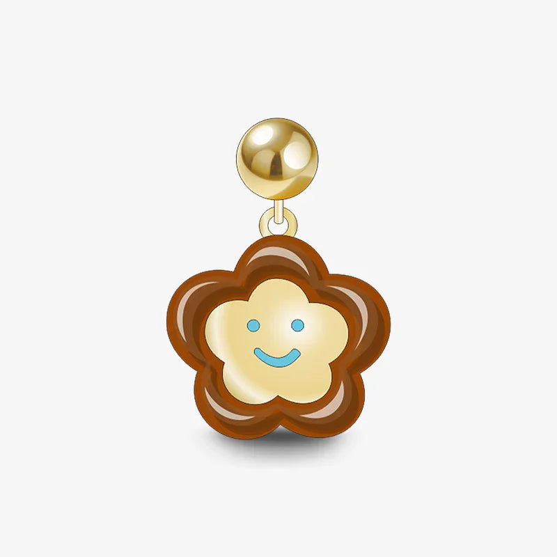 Gold-plated flower-shaped earring with a brown outline and a smiling face design