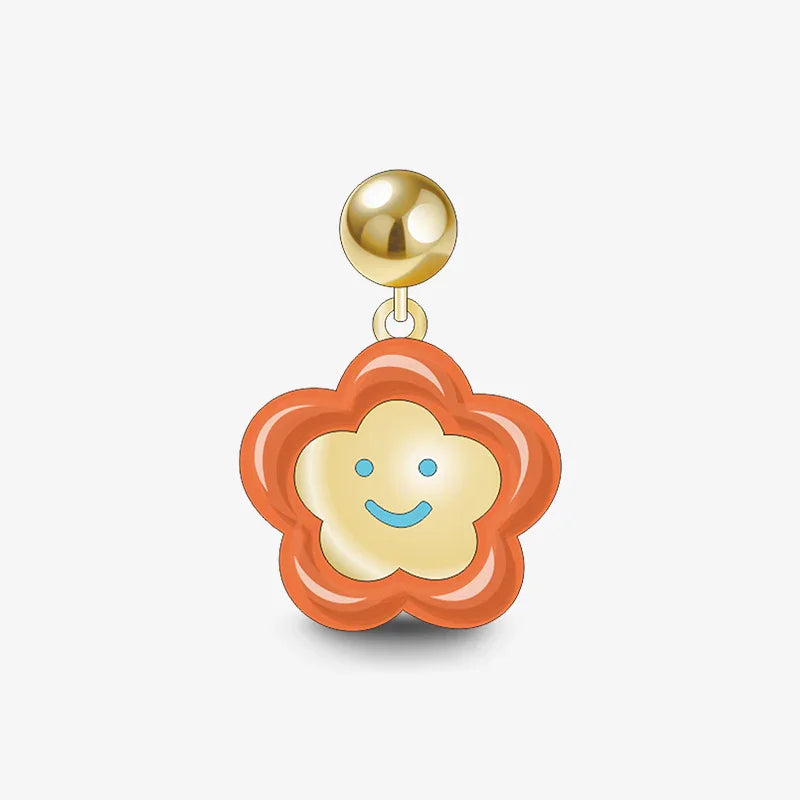 Gold-plated flower-shaped earring with orange outline and smiling face charm