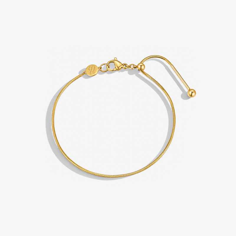 Minimalist gold-plated bracelet with adjustable clasp on a white background