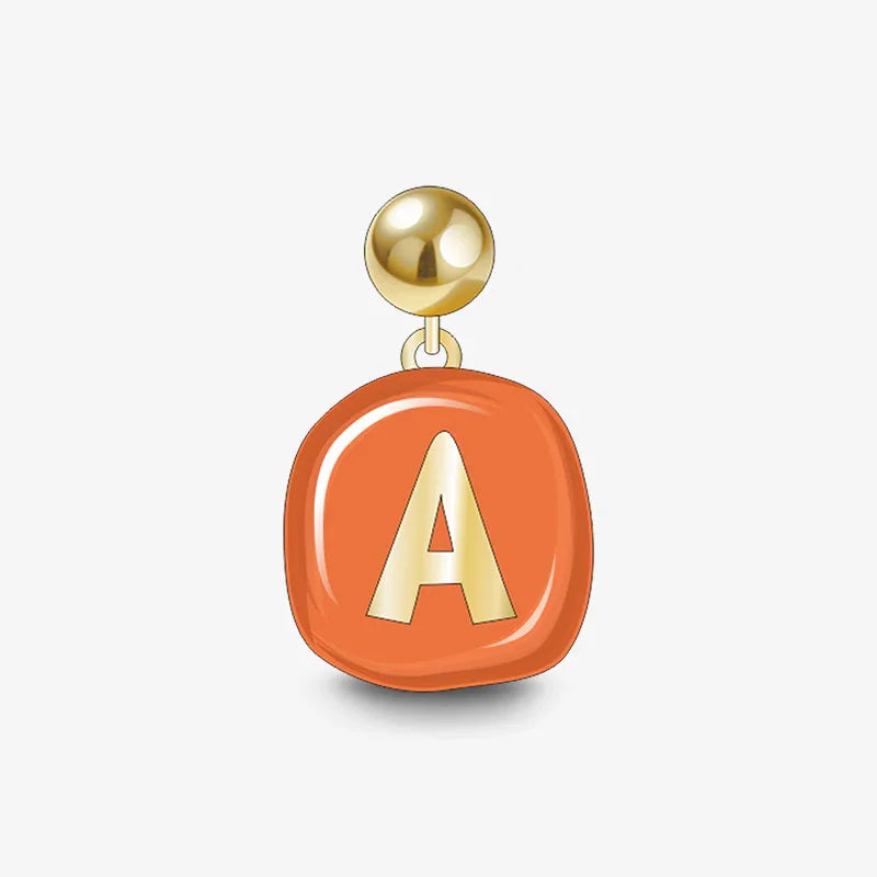 Gold-plated letter A pendant with orange enamel accent on white background