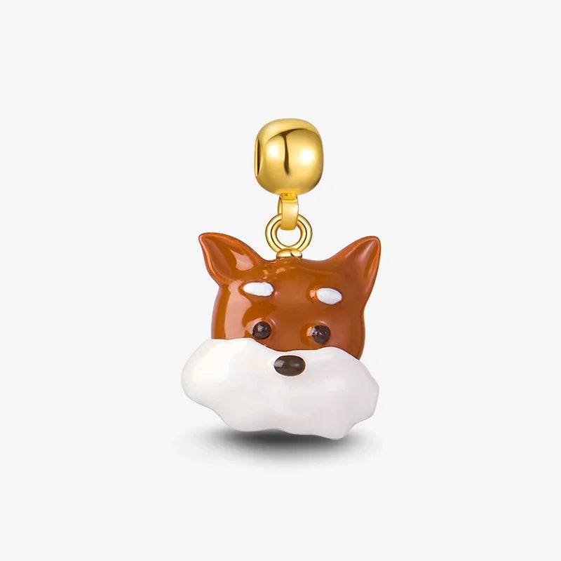 Gold-plated enamel fox charm pendant with brown and white details on white background