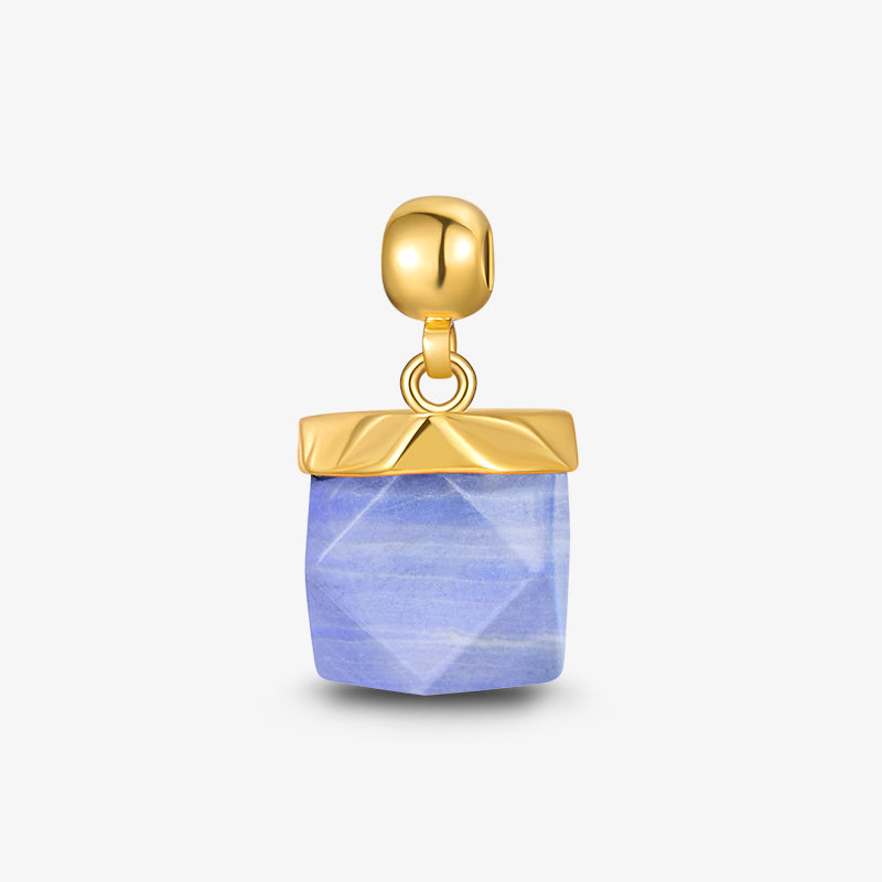 Gold-plated pendant with faceted blue gemstone on a white background
