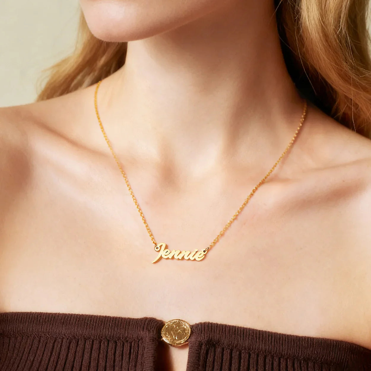 Gold-plated name necklace with 'Jennie' script on woman's neck, elegant jewelry style