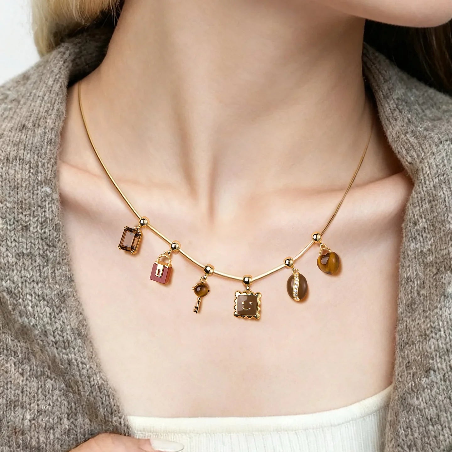 Woman wearing gold-plated necklace with multiple unique charms and statement pendants