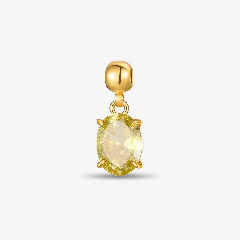 Gold-plated charm with yellow oval gemstone on white background
