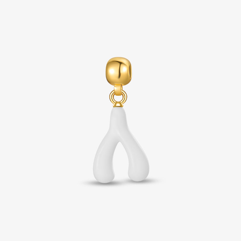 Gold-plated earring with white wishbone-shaped charm on white background