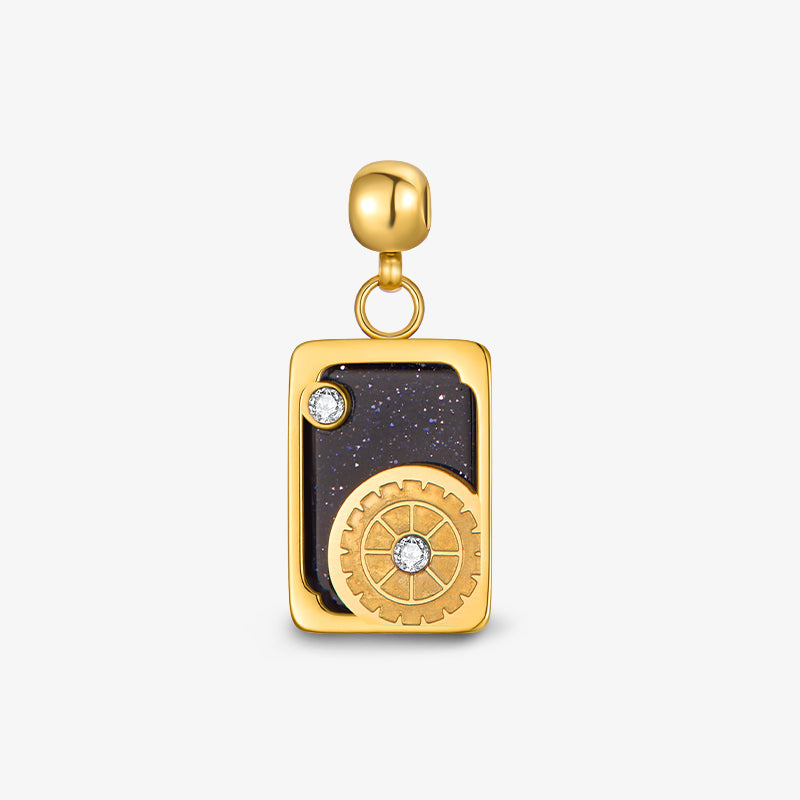 Gold-plated rectangular pendant with black stone, gear detail, and small crystal accents
