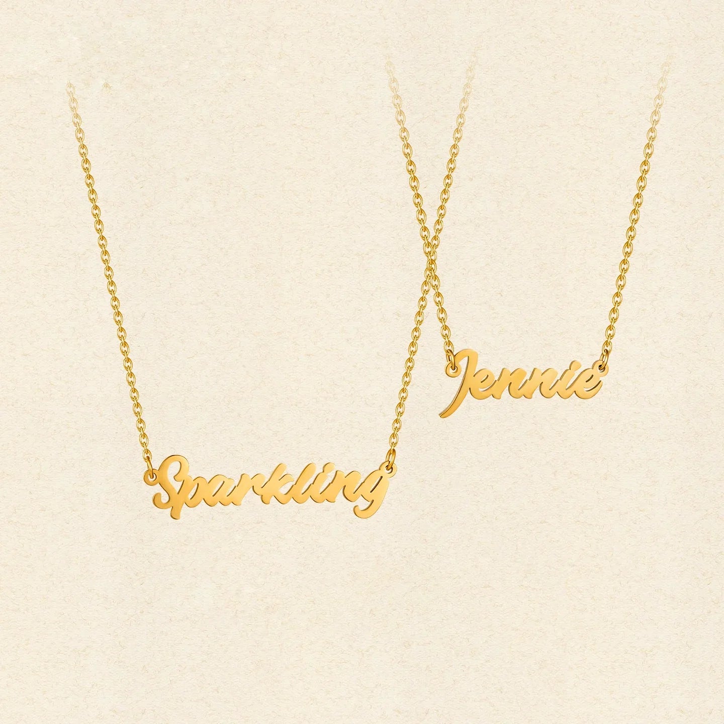 Gold-plated necklaces with script name pendants reading Sparkling and Jennie on light background