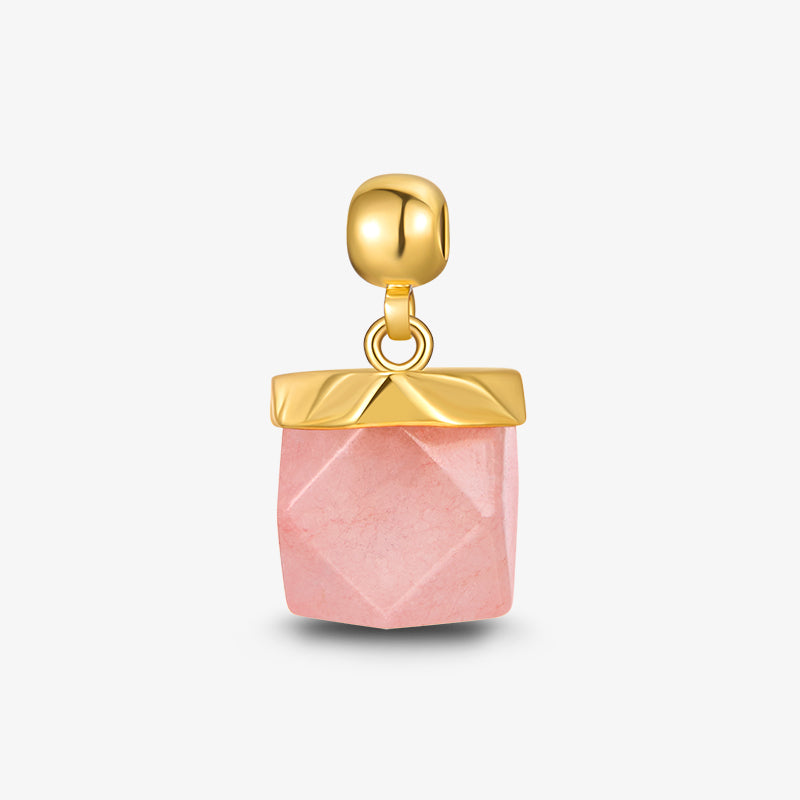 Gold-plated pendant with faceted pink stone charm on a white background