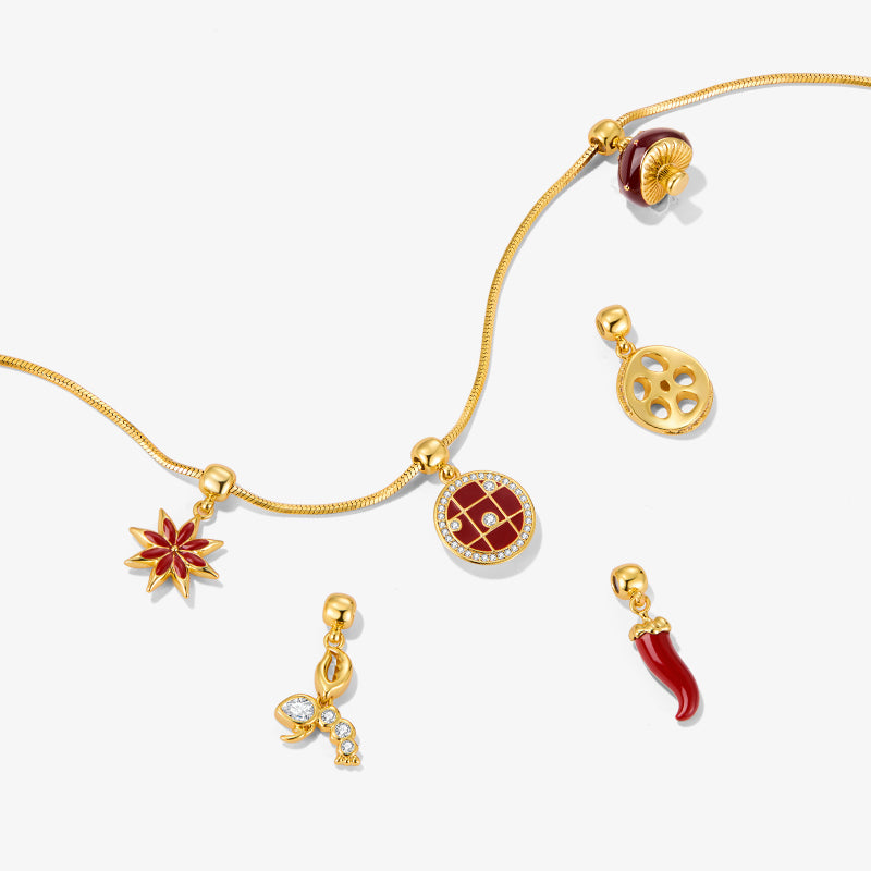 Gold-plated necklace with red and gold charms, gemstone accents, and unique pendant designs