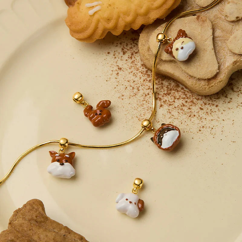 Gold-plated animal charm necklaces and pendants with cookies on a beige plate