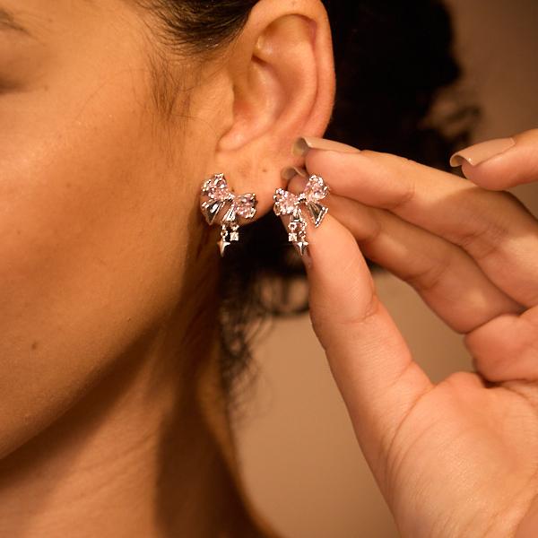 Woman wearing sparkling statement crystal earrings with geometric shapes, close-up
