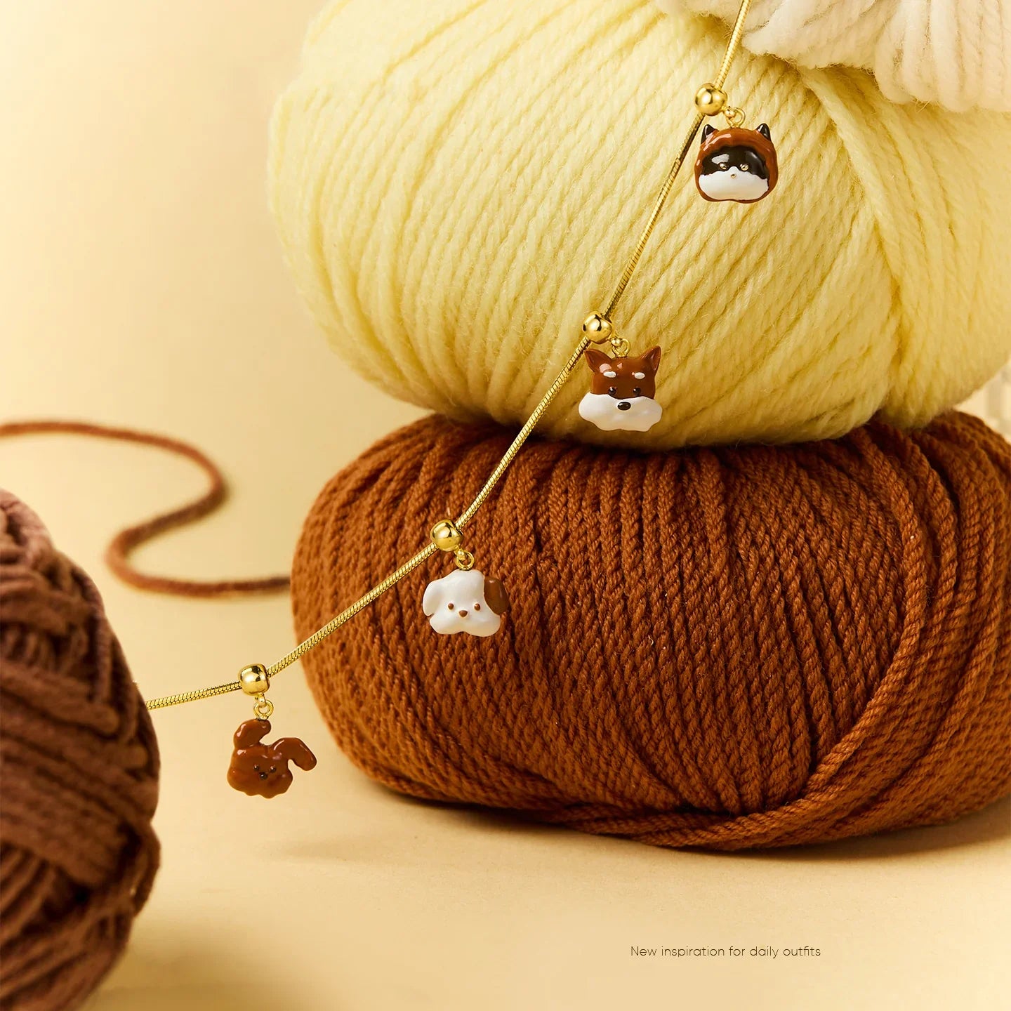 Gold-plated necklace with dog and cat charms displayed on yarn balls, cute animal jewelry