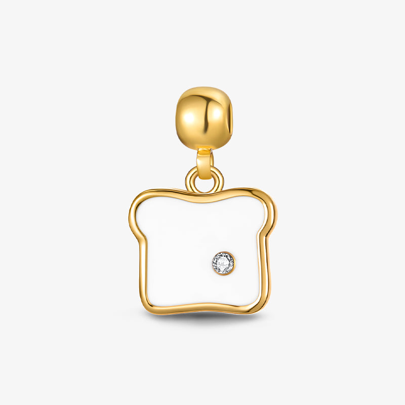 Gold-plated toast-shaped charm with white enamel and single clear crystal accent