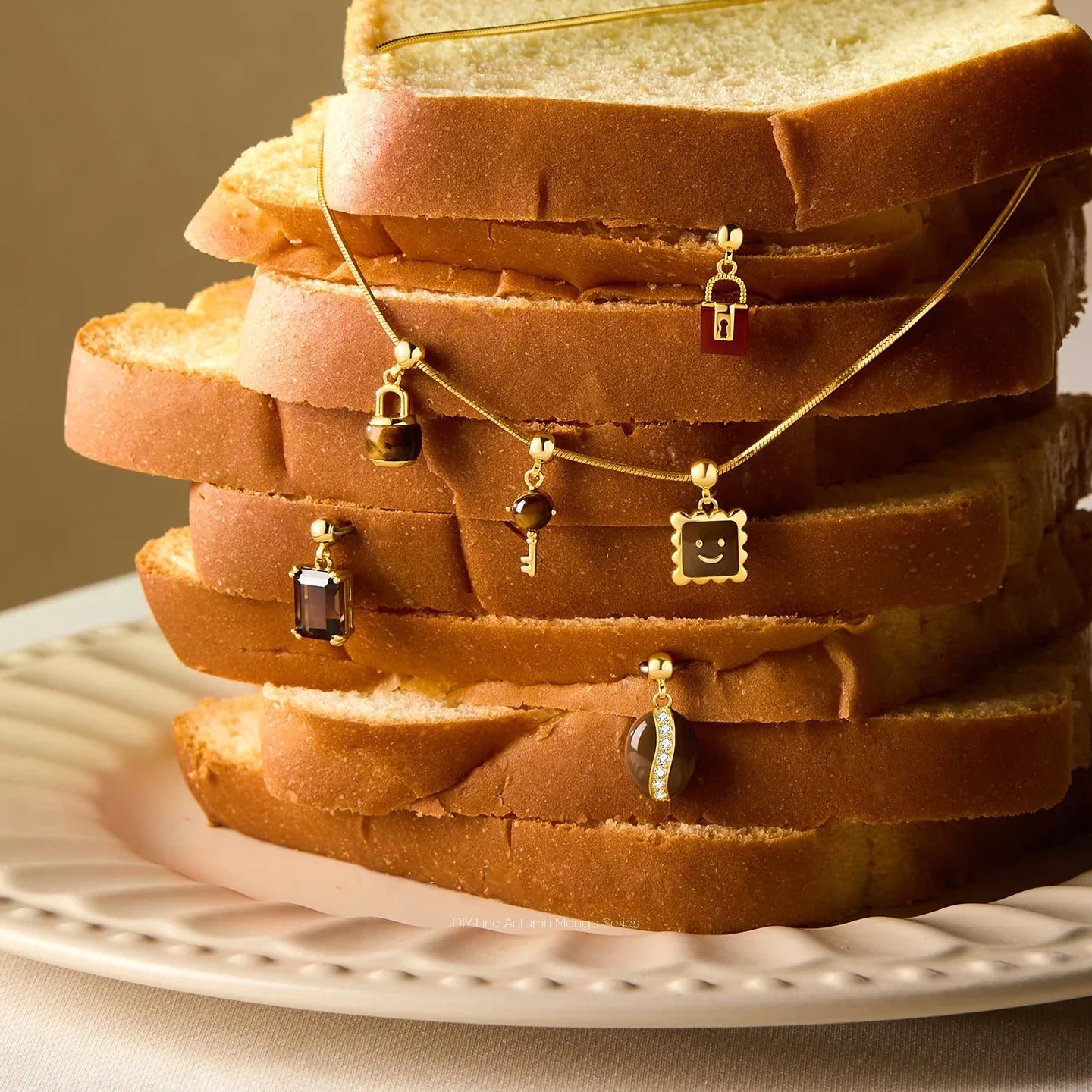 Gold-plated charm necklaces with unique pendants displayed on sliced bread stack