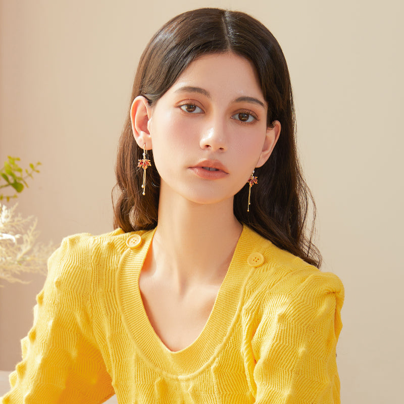 Woman wearing statement gold-plated dangle earrings and yellow textured sweater