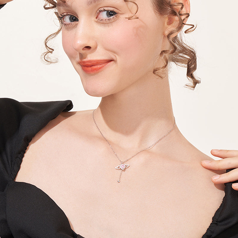 Woman wearing elegant silver butterfly pendant necklace with heart-shaped gemstone