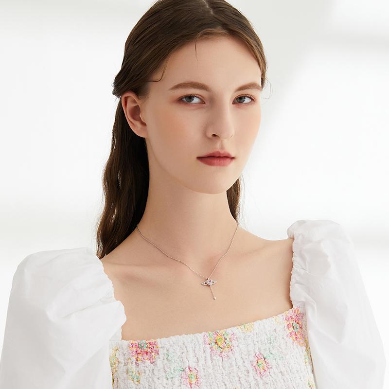 Woman wearing delicate gold-plated pendant necklace and white puff sleeve dress