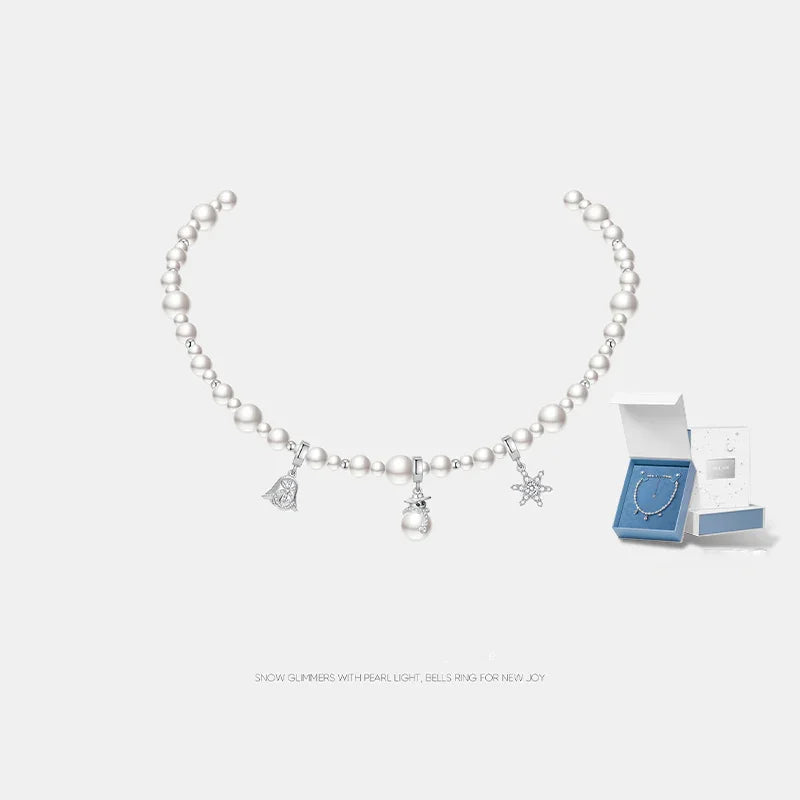 Pearl beaded necklace with silver charms and gift box on white background