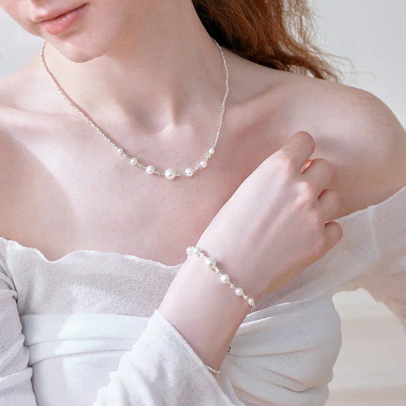 Woman wearing an elegant pearl necklace and matching pearl bracelet